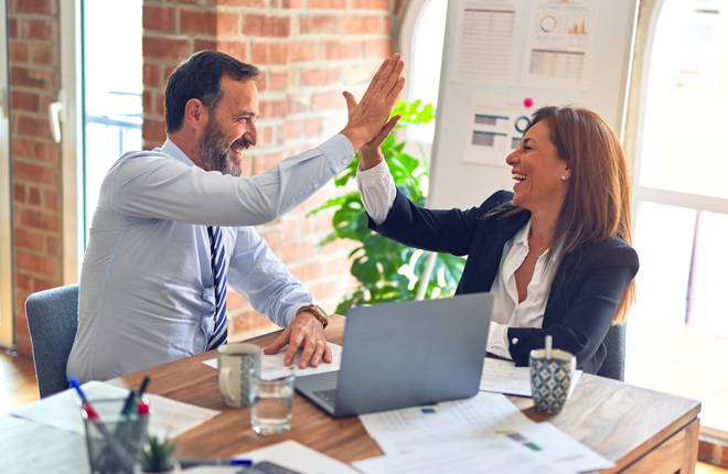 Two people giving high five at the office